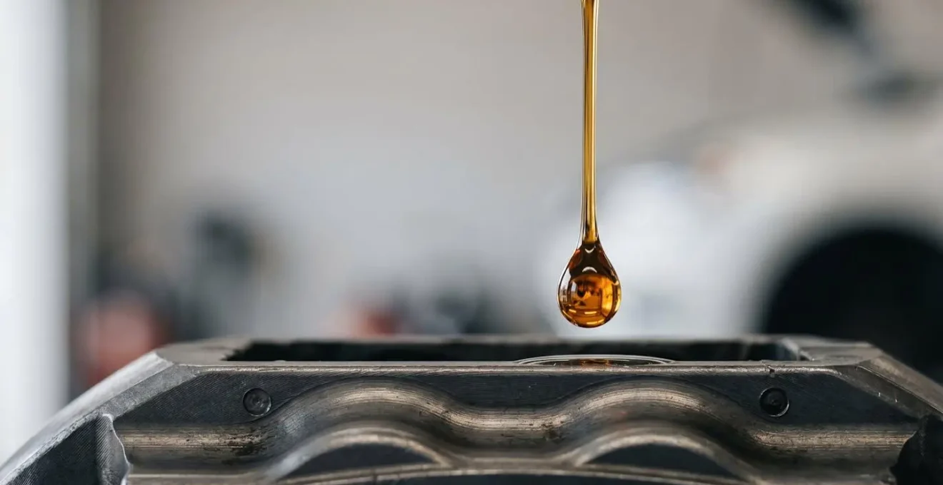 Gros plan symbolique sur une goutte de liquide de frein reflétant la puissance mécanique transmise aux roues d'une voiture