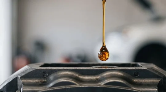 Gros plan symbolique sur une goutte de liquide de frein reflétant la puissance mécanique transmise aux roues d'une voiture
