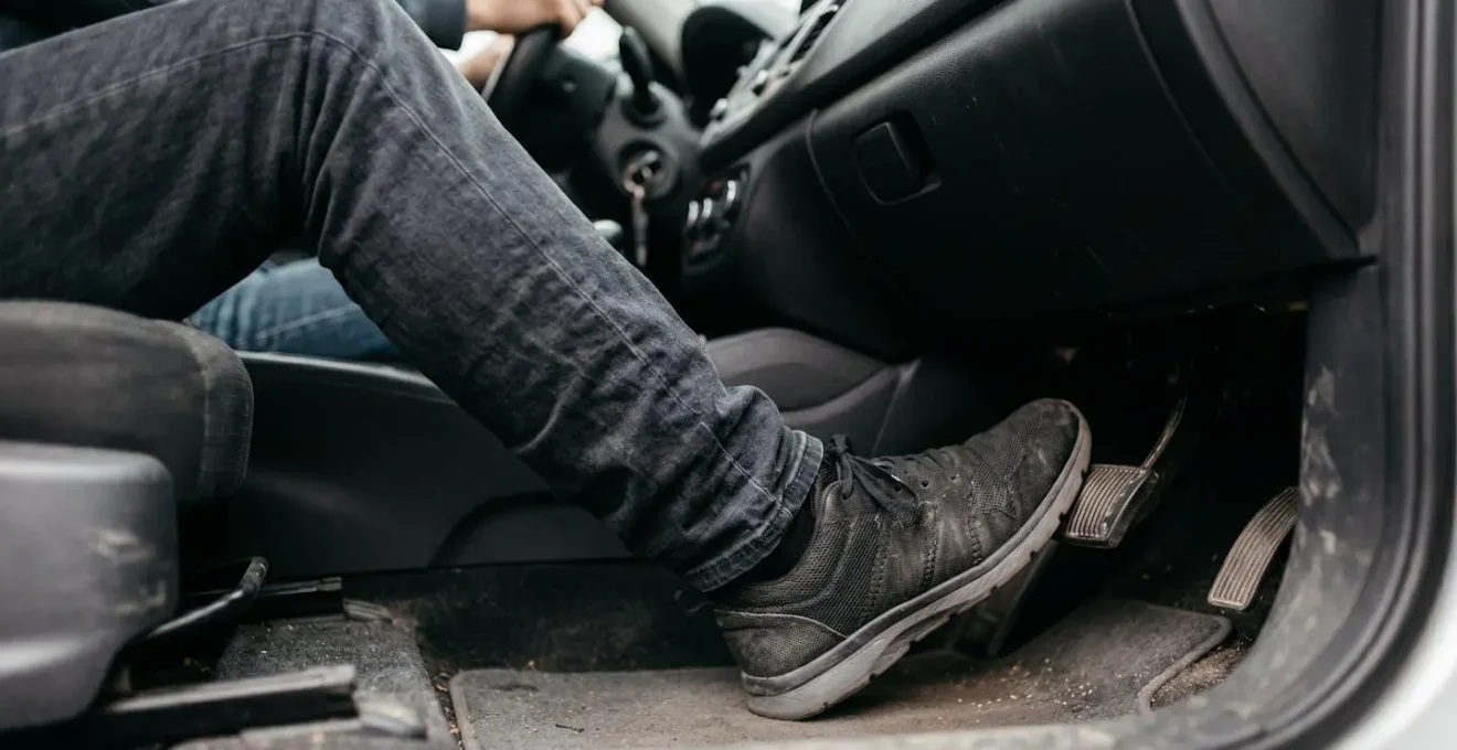 Gros plan sur le pied d'un conducteur écrasant la pédale de frein lors d'un freinage d'urgence avec ABS