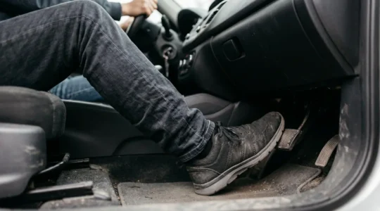 Gros plan sur le pied d'un conducteur écrasant la pédale de frein lors d'un freinage d'urgence avec ABS