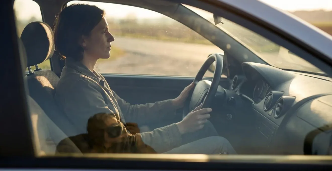 Conducteur assis avec une posture alignée, dos droit et mains détendues sur le volant, illustrant l'équilibre de la colonne vertébrale au volant