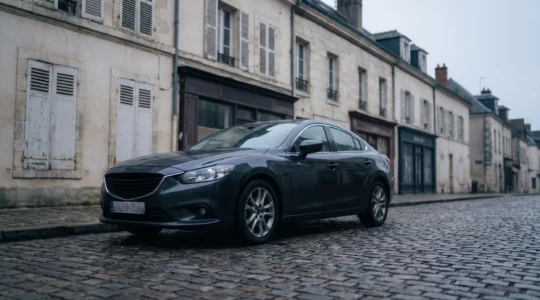 Voiture citadine garee dans une rue europeenne, symbolisant l'obligation legale d'assurance responsabilite civile automobile